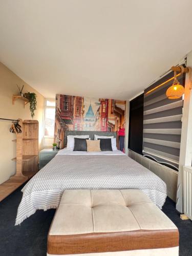 ein Schlafzimmer mit einem großen Bett und einem getufteten Sofa in der Unterkunft Cozy dublex in city center, 3rd floor in Istanbul