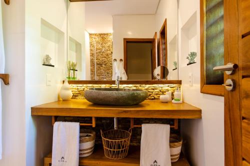 a bathroom with a stone sink and a mirror at Aldeia Jericoacoara - Suites Privativas in Jericoacoara