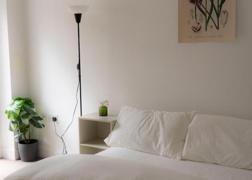 a white bed with a white pillow and a lamp at Bridge & Shard Hideaway in London