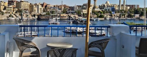 a balcony with two chairs and a view of a harbor at La Terrace in Aswan