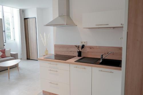 a kitchen with white cabinets and a sink at Château de l'insolas in Villeneuve-lès-Avignon