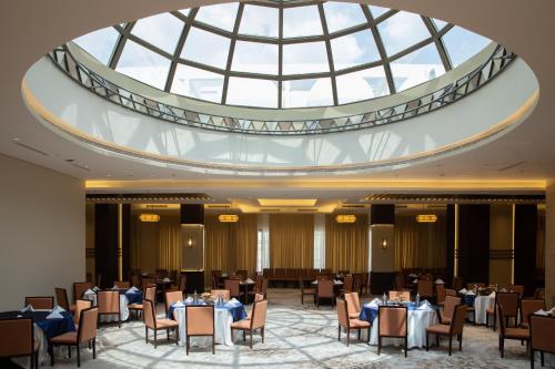 فندق صن آند موون بكة في مكة المكرمة: غرفة طعام بها طاولات وكراسي وسقف ثابت