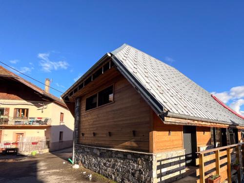 ein Holzgebäude mit einem Zinndach oben in der Unterkunft La belle grange in Mercury
