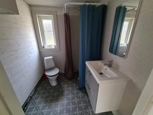 a bathroom with a sink and a toilet and a mirror at Charmigt hus och mysigt boende! in Hudiksvall