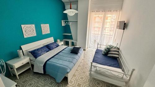 Dormitorio azul con cama y ventana en Reginella Guest House, en Salerno