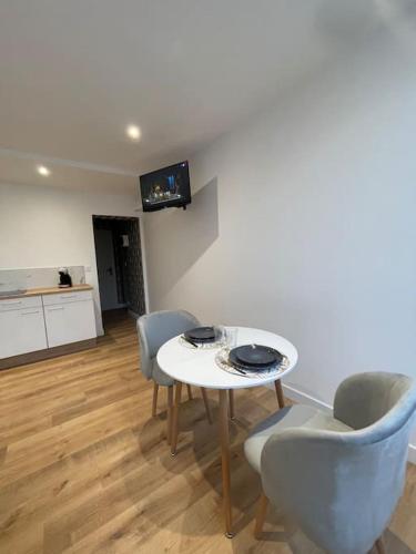 un salon avec une table et des chaises blanches dans l'établissement Appartement hyper cosy, à Boulogne-sur-Mer