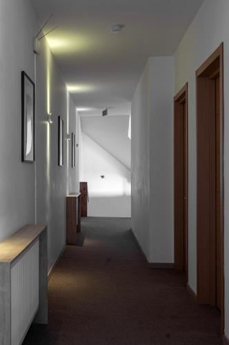 a hallway with white walls and a long hallway with a staircase at Alliance Hotel in Tbilisi City