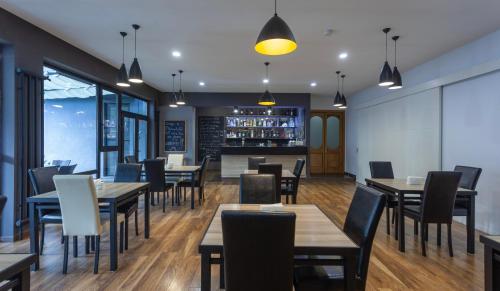 a restaurant with tables and chairs and a bar at Alliance Hotel in Tbilisi City
