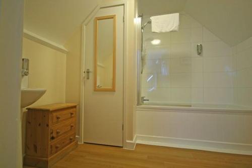 y baño con ducha y lavamanos. en Grooms Cottage en Leighton Buzzard