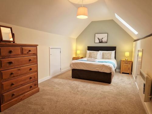 a bedroom with a king sized bed and a dresser at The Homestead in Leighton Buzzard