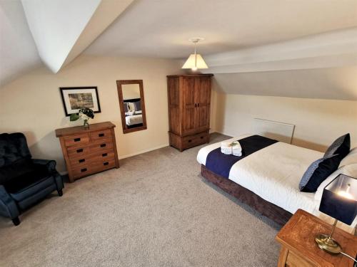 a bedroom with a bed and a chair at The Old Stables in Leighton Buzzard