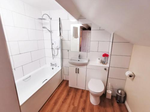 a bathroom with a toilet and a sink and a bath tub at The Old Stables in Leighton Buzzard