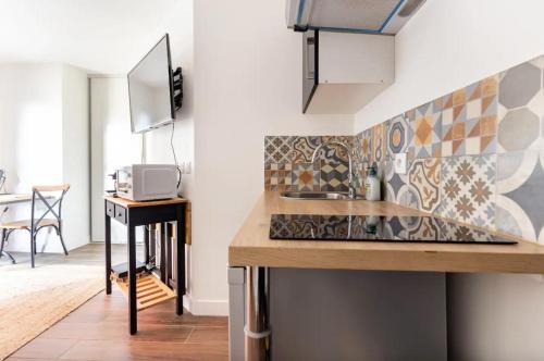 a kitchen with a sink and a counter top at L'Escapade Paris in Le Kremlin-Bicêtre