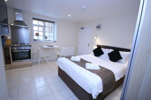 a bedroom with a large bed and a kitchen at The Egg Room in Ivinghoe