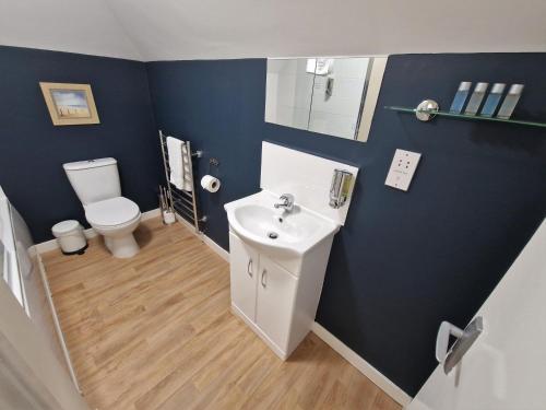 uma casa de banho com um lavatório branco e um WC. em Lime Kiln em Leighton Buzzard