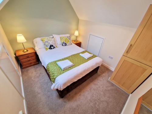 a small bedroom with a bed with two pillows at Lime Kiln in Leighton Buzzard