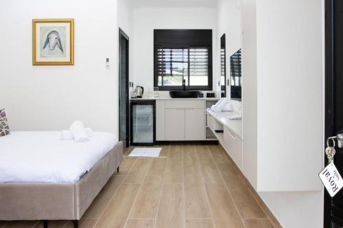 a bedroom with a bed and a kitchen at Royal Suites Dalia - וילה עם 4 סוויטות מהממות, בריכה מחוממת וג'קוזי in Dāliyat el Karmil