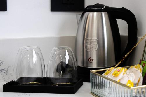 two glasses and a tea kettle on a counter at Royal Suites Dalia - וילה עם 4 סוויטות מהממות, בריכה מחוממת וג'קוזי in Dāliyat el Karmil