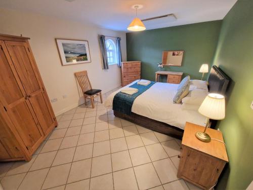 um quarto com uma cama king-size e paredes verdes em Town End em Leighton Buzzard