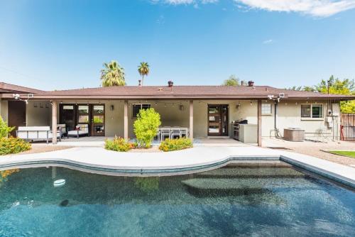 a house with a swimming pool in front of a house at Heated Pool Outdoor Kitchen Patio Modern Design in Scottsdale