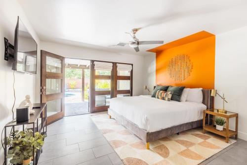 - une chambre avec un lit et un mur orange dans l'établissement Heated Pool Outdoor Kitchen Patio Modern Design, à Scottsdale
