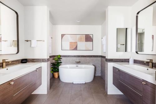 La salle de bains est pourvue de 2 lavabos, d'une baignoire et de 2 miroirs. dans l'établissement Heated Pool Outdoor Kitchen Patio Modern Design, à Scottsdale