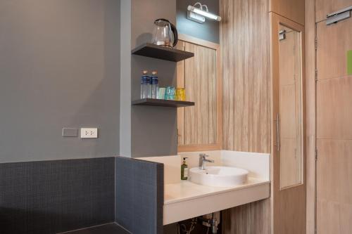 a bathroom with a sink and a mirror at iCheck inn Gems Center Silom in Bangkok