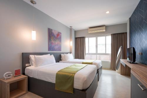 a hotel room with a bed and a television at iCheck inn Gems Center Silom in Bangkok