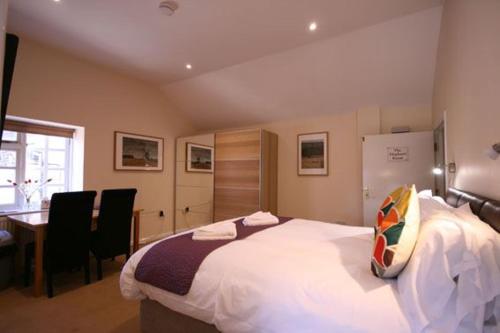 a bedroom with a large bed with a desk and chairs at The Elephant Room in Ivinghoe