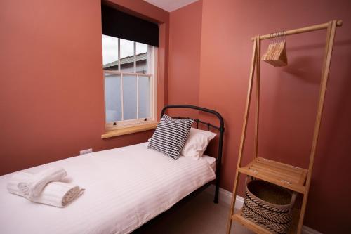 a small bedroom with a bed and a window at Ciliau in Cardigan
