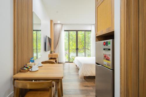 a room with a bed and a table and a refrigerator at Studio-Vincent Apartment HaNoi in Hanoi