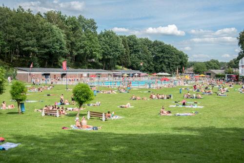a large group of people laying on the grass in a field at Chalet 2Relax in Zutendaal
