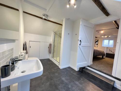 a bathroom with a sink and a mirror at Dolls House Cottage in Hilborough