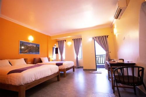 a hotel room with two beds and a desk at Daun Penh Palace Boutique in Phnom Penh