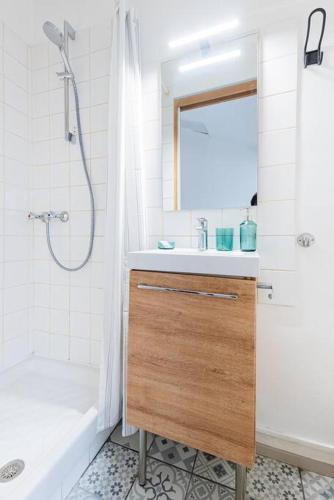 une salle de bain blanche avec un lavabo et une douche dans l'établissement Le Tiffany, Beau T2 en Duplex, Beaux Arts, à Montpellier
