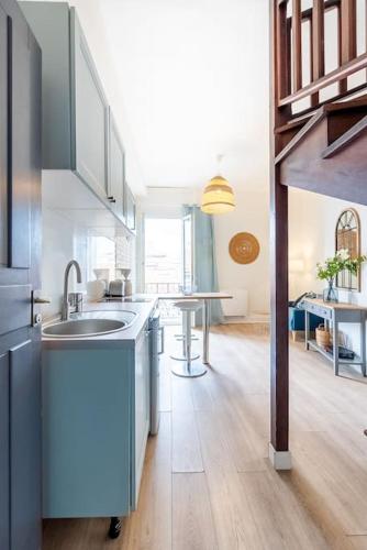 une grande cuisine avec un évier et une table dans l'établissement Le Tiffany, Beau T2 en Duplex, Beaux Arts, à Montpellier