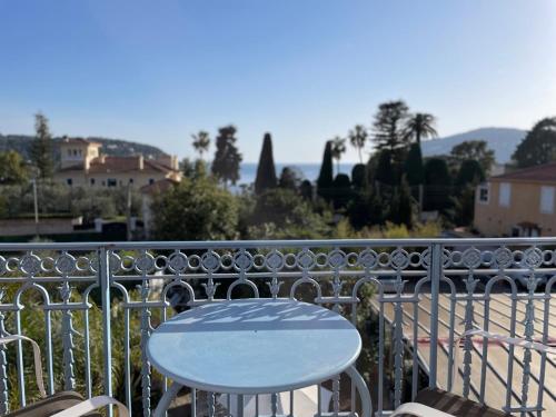 a white table and chairs on a balcony at Hôtel La Villa Patricia - Charme et Tradition in Villefranche-sur-Mer