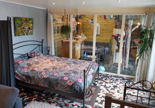 een slaapkamer met een bed met een bloemdekbed bij Gastenverblijf 'De Hupsakeet' in Barneveld