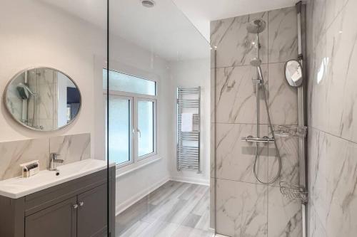 a bathroom with a shower and a sink and a mirror at Windsor Oasis: Tranquil Retreat with Heated Pool in Windsor