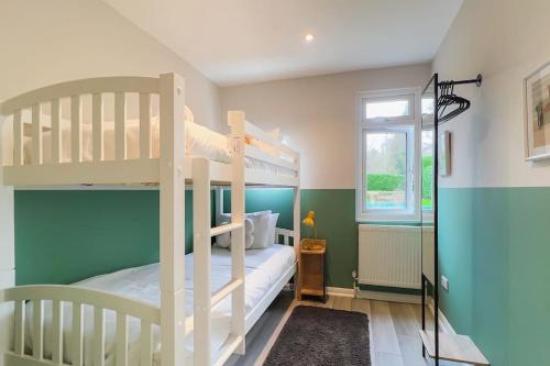 a bedroom with two bunk beds and a window at Windsor Oasis: Tranquil Retreat with Heated Pool in Windsor