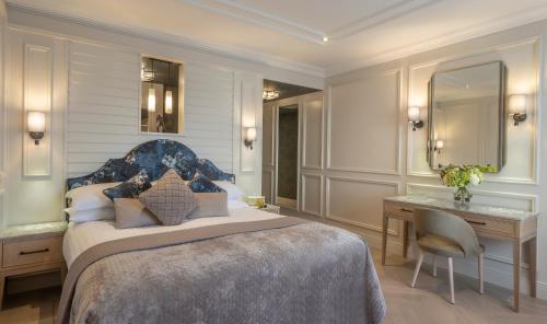 a bedroom with a king sized bed and a desk at The Brehon Hotel & Spa in Killarney