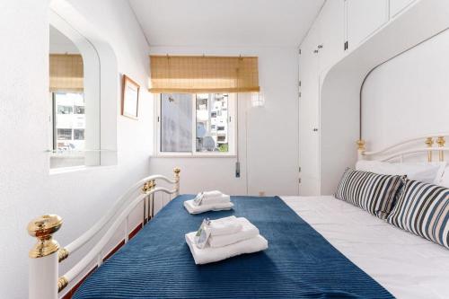a bedroom with a bed with towels on it at Acolhedor apartamento com Wifi a passos do Mar in Luz