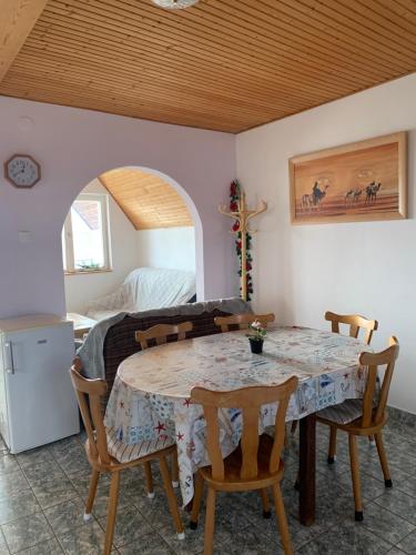 a dining room with a table and chairs and a bed at VIL'LAGUNA Apartment with view of Balaton in Zánka