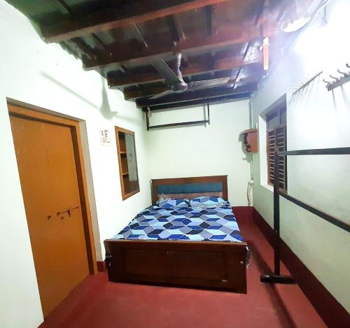 a small bedroom with a bed in a room at Hallimane Homestay in Udupi