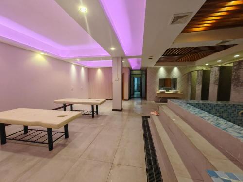 a lobby with a pool and purple lighting at 九号公馆 in Ban Dông-Naxôk