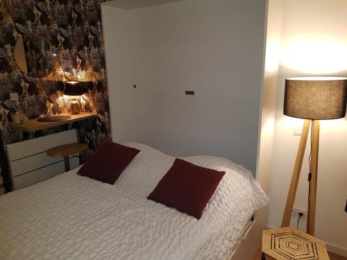 une chambre avec un lit et une table avec une lampe dans l'établissement studio zen, à Vannes