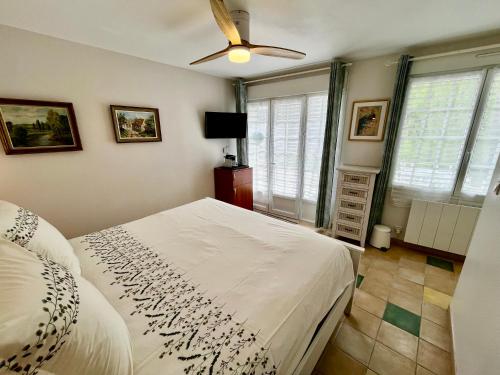 a bedroom with a bed and a ceiling fan at Sans Souci Bed and Breakfast Luxe Heated Pool and Restaurant in Luzillé