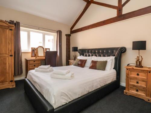 a bedroom with a large bed with two towels on it at Gamekeepers Cottage in St Asaph