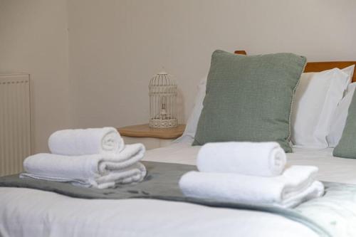 a group of towels sitting on top of a bed at Magnificent Period Country House in Rothley