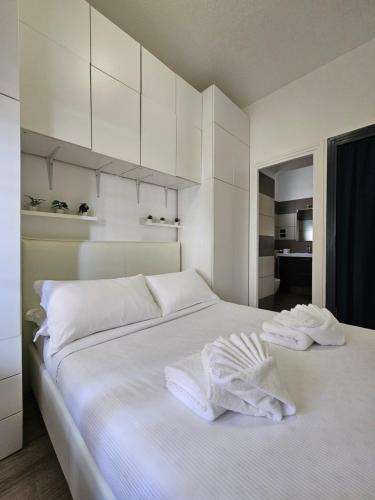 a white bedroom with two towels on a bed at ROME HOLIDAY QUIET AND CONFORTABLE APARTMENT in Rome